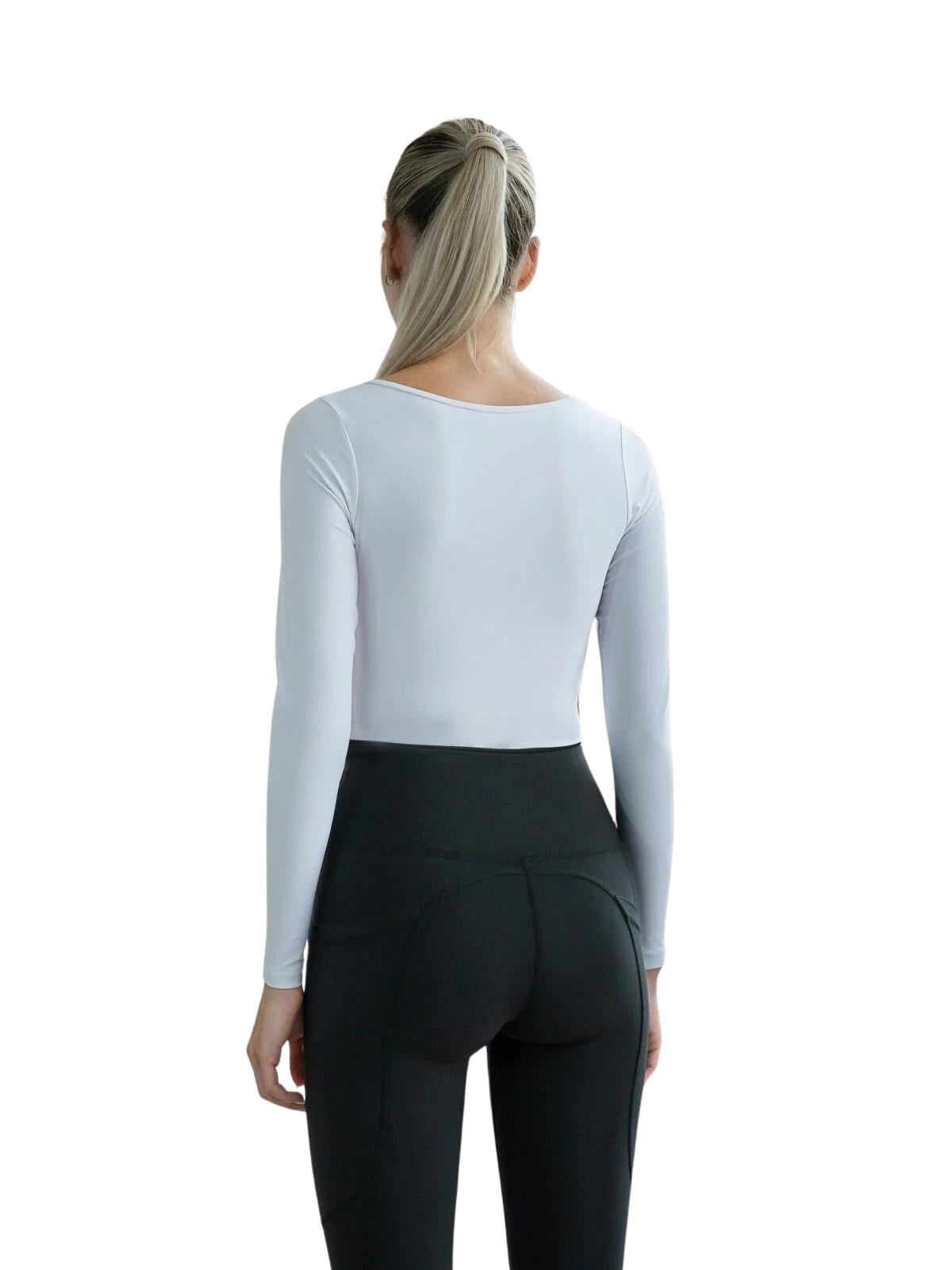 Frau mit Pferdeschwanz trägt Lisminas 092 Langarm-Top in Weiss und schwarze Leggings, blickt abgewandt, bereit für Yoga.
